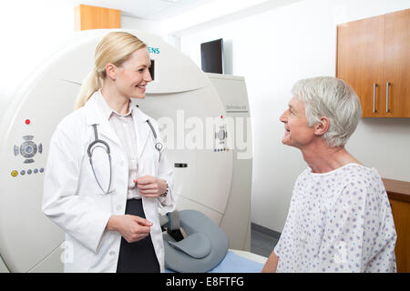 Weiblich-Arzt im Gespräch mit männlichen Patienten neben MRI Scanner Stockfoto