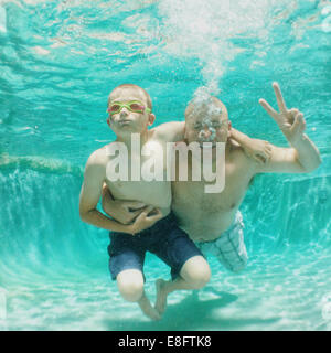 Vater und Sohn schwimmen im Pool, Sommerfamilie. Kinderpool-Party