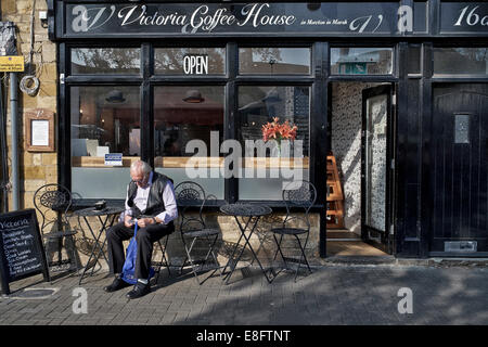 Straßencafé. Der Mann saß allein in einem Straßencafé. Moreton im Marsh England UK Stockfoto