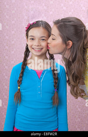 Mutter küssen Tochter auf Wange Stockfoto