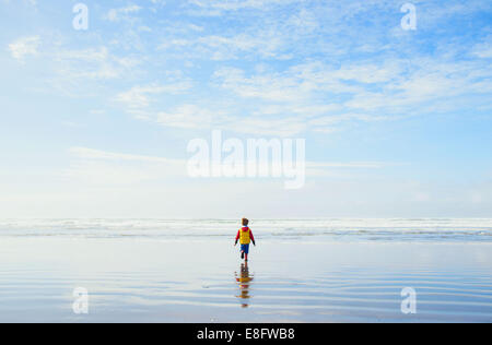 Junge am Strand, der zum Meer geht, USA Stockfoto
