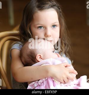 Kuscheln Babyschwester Mädchen (4-5 Jahre) Stockfoto