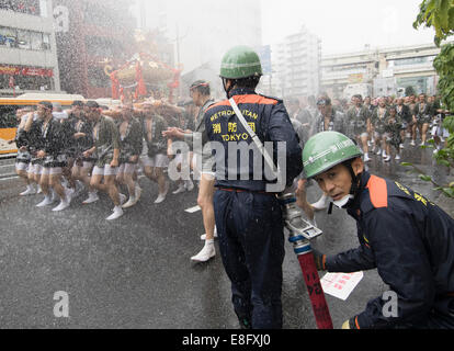 Feuerwehrleute genießen die Mikoshi in Fukagawa Fetival aka Wasser werfen Festival am Tomioka Hachimangu Schrein, Tokyo, Japan statt Stockfoto