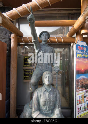 Statue des jungen japanischen Männer zeigen bis zum Gipfel auf Fuji Subaru Line 5th Station auf dem Mount Fuji. Stockfoto