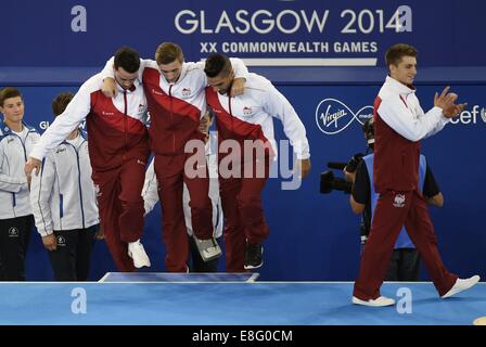 Max Whitlock und Louis Smith helfen Verletzten Sam Oldham auf die Bühne. Mens Kunstturnen - SSE Hydro - Glasgow - UK- Stockfoto