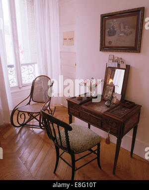 Antiker Schreibtisch und Stuhl im Schlafzimmer mit Formholz Schaukelstuhl und Parkett Stockfoto