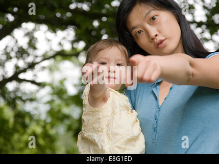 ein gemischter ethnischer Herkunft (ostasiatische / caucasian) weiblichen Kleinkind in den Arm der Mutter Koreanisch East Asian, zeigen statt Stockfoto