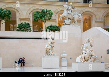 Mann und Frau auf Bank im Abschnitt Richelieu des Musée du Louvre, Paris, Frankreich Stockfoto