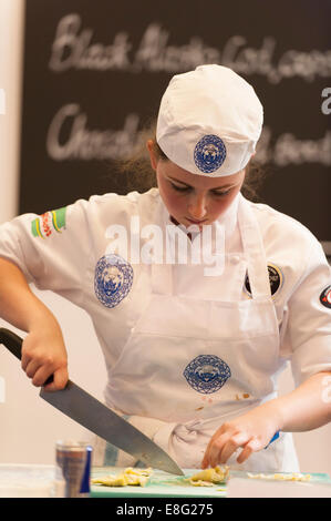 Earls Court, London UK. 7. Oktober 2014. Die Restaurantküche zeigen Wettbewerb hält jung National Koch des Jahres, die 4. Craft Guild of Chefs Wettbewerb für Köche im Alter von 18 bis 23 mit 8 Köche im Wettbewerb live im Finale. April Lily Partridge von The Club at The Ivy in London das Menü vorbereiten. Bildnachweis: Malcolm Park Leitartikel/Alamy Live-Nachrichten. Stockfoto