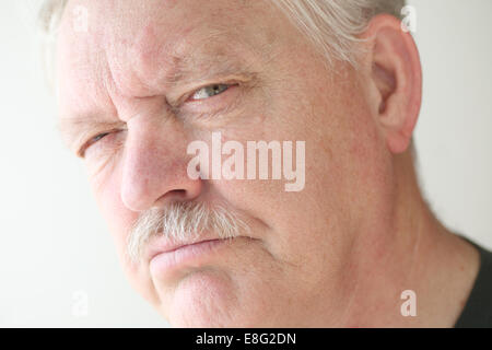 Älteren Mann mit einem verdächtigen oder skeptisch Ausdruck Stockfoto