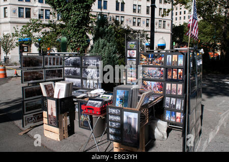 Ein Geschäft hinter einer großen Anzeige von Fotos, Schilder und andere Souvenirs aus New York am Battery Park. Anbieter verkaufen Postkarten und Bilder in Manhattan, New York. Battery Park City. Eine Promenade entlang des Hudson River, der in Tribeca Südende in Rockefeller Park beginnt und auf Staten Island Ferry Terminal zu erreichen, teilen dem Rampenlicht mit modernen Gebäuden, dass New York Socialite Leben. Wird ein sehr geschäftiger Ort für viele Touristen Souvenir Verkäufer wählen Sie diesen Ort, um ihre Produkte zu verkaufen. Stockfoto