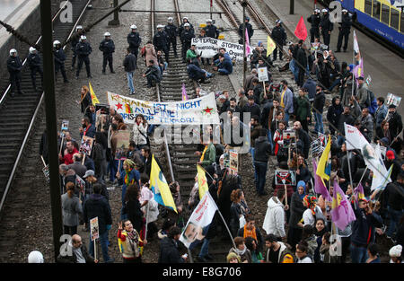 Hamburg, Deutschland. 7. Oktober 2014. Eine Gruppe des kurdischen Volkes besetzen die Gleise am Hauptbahnhof in Hamburg, Deutschland, 7. Oktober 2014. Ein paar Welle Flaggen mit dem Gesicht des Anführers der kurdischen Arbeiterpartei, die in der Türkei verboten ist. Es gab erhebliche Verzögerungen im Eisenbahnverkehr. Foto: CHRISTIAN CHARISIUS/Dpa/Alamy Live News Stockfoto