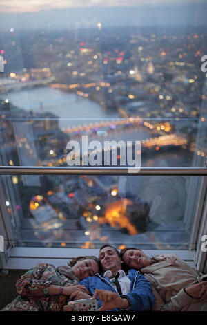 Spaß Portraitfoto von drei Freunden am oberen Rand der Scherbe in London bei Sonnenuntergang Stockfoto