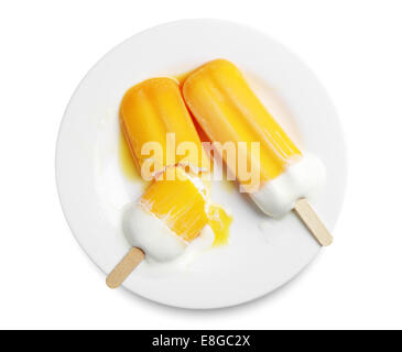 Orange Eis am Stiel schmelzen in einem Teller auf weißem Hintergrund Stockfoto