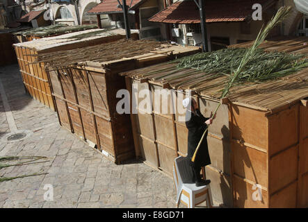 Jerusalem. 7. Oktober 2014. Ultra-orthodoxer Jude baut eine Laubhütte, einen rituellen Stand während der jüdische Feiertag von Sukkot auf einem religiösen Viertel von Jerusalem am 7. Oktober 2014 verwendet. Religiöse Juden bauen temporäre Bauten für das einwöchige Festival zum Gedenken an den 40 Jahren des Reisens in der Wüste nach dem Auszug aus der Sklaverei in Ägypten. Donnerstag beginnt das diesjährige Sukkot. © Gil Cohen Magen/Xinhua/Alamy Live-Nachrichten Stockfoto