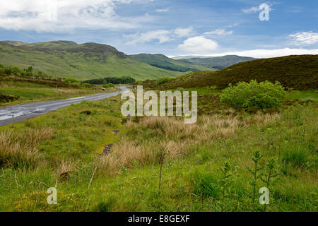 Riesige & malerische Landschaft mit schmale Straße schlängelt sich durch die sanften, grünen Hügeln, Heidekraut und Berge der schottischen highlands Stockfoto