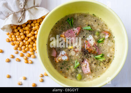 Erbsensuppe mit Fleisch in eine Schüssel geben. In der Nähe von Erbsen in meschotschek. Stockfoto