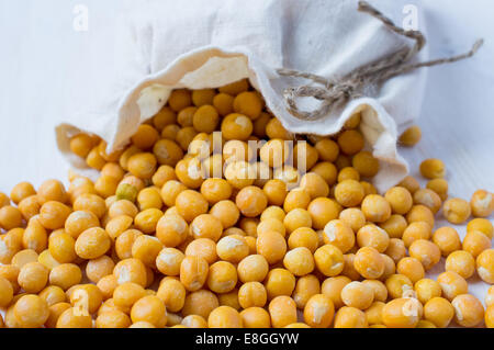 Gelbe feste getrocknete Erbsen aus der Tasche zu verschütten Stockfoto