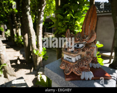 Shisa vor Haus auf Bise Fukugi Tree Road, Motobu, Okinawa. Stockfoto