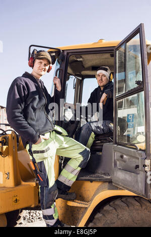 Porträt von zuversichtlich Bauarbeiter am Bagger Stockfoto