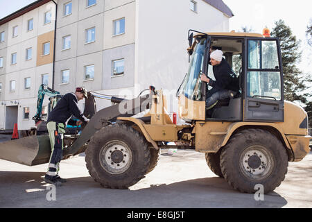 Arbeitnehmer mit Bagger auf Baustelle Stockfoto