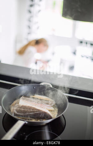 Fisch braten in der Pfanne auf Herd Stockfoto