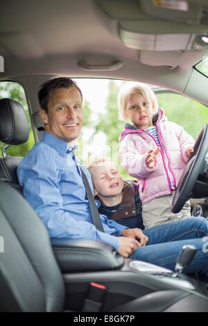 Porträt der glückliche Vater mit Kindern im Auto Stockfoto