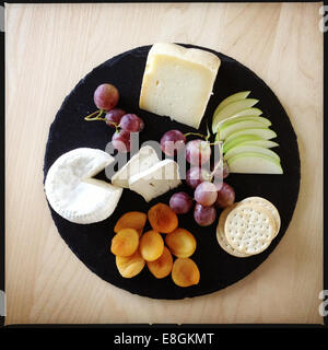 Italien-Käseplatte: Käse, Apfel, getrocknete Aprikosen, Cracker, Rosinen Stockfoto