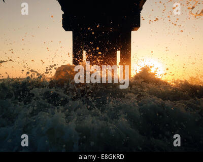 Wellen schlagen unter Pier bei Sonnenuntergang, St Augustine Beach, Florida, USA Stockfoto