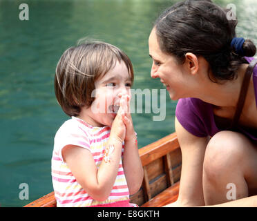 Mutter und Tochter sitzen auf einem Boot vor Lachen Stockfoto