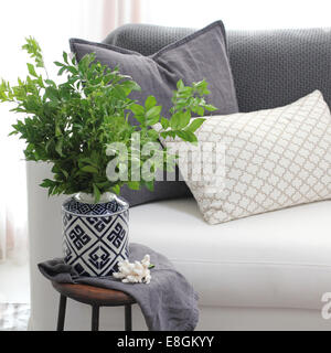 Wohnzimmer-Couch mit Beistelltisch und Pflanze