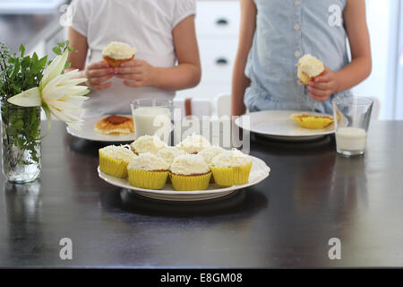 Zwei Mädchen mit Cupcakes in der Küche Stockfoto