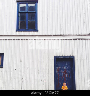 Fredrikstad, Norwegen Boy (10-11) sitzen gegen Haus Stockfoto