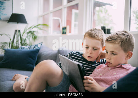 Brüder mit digital-Tablette zu Hause auf sofa Stockfoto