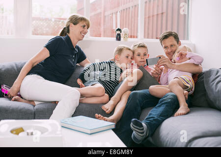 Familie mit Smartphone zu Hause auf sofa Stockfoto