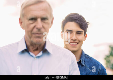 Porträt des jungen Mann lächelnd mit Großvater im Vordergrund Stockfoto