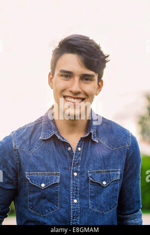 Porträt von zuversichtlich junger Mann lächelnd im freien Stockfoto