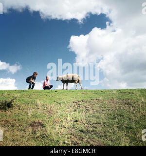 Zwei Kinder mit einem Schaf auf einem Feld Stockfoto