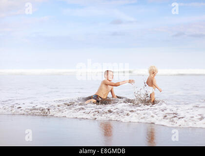 Zwei Brüder spielen im Meer Stockfoto