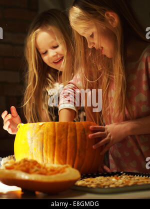 Zwei Mädchen bereiten einen Kürbis für Halloween, Schweden Stockfoto