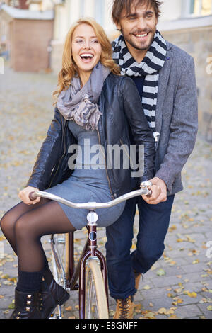 Mann trägt seine Freundin auf dem Fahrrad Stockfoto