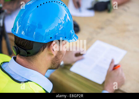 Rückansicht des Architekten lesen Dokument auf Baustelle Stockfoto