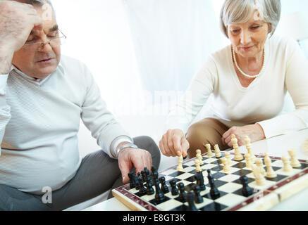 Älteres Paar beim Schachspiel zu Hause Stockfoto