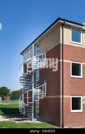 Äußere Metallspirale Feuerleiter Treppen außerhalb des Gebäudes. Stockfoto