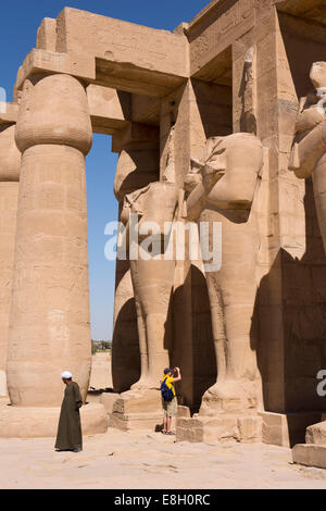 Ägypten, Luxor, Ramesseum, Touristen und lokalen Führer unten kopflosen Statuen von Ramses II. Stockfoto