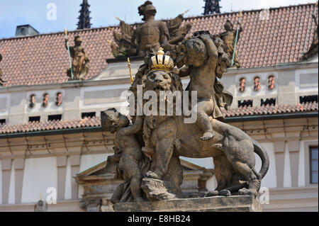 Statuen von einem Löwen trägt eine goldene Krone und zwei Putten an der Wand des Tores der Prager Burg, Prag, Tschechische Republik. Stockfoto