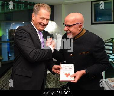 Frankfurt, Deutschland. 8. Oktober erhält 2014.Finnish Präsident Sauli Niinistoe (L) ein Buch von brasilianische Autor Paulo Coelho auf der Buchmesse in Frankfurt Am Main, Deutschland, 7. Oktober 2014. Die weltweit größte Buchmesse dauert bis zum 12. Oktober 2014. Finnland ist das diesjährige Gastland. © Dpa picture-Alliance/Alamy Live News Stockfoto