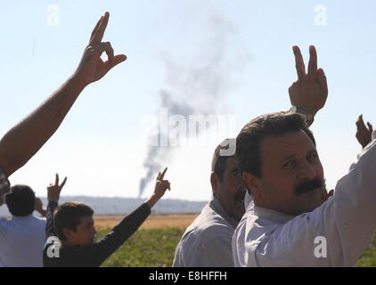 Suruc, Türkei. 8. Oktober 2014. Türkische Kurden jubelten als US militärische hit islamischer Staat Ziele in Kobane Syrien. Hunderte von türkischen Kurden kamen zu Marsitpinar eine Provinz in Suruc, Türkei, über ein Feld in Kobane sehen wo Amerika Luftangriffe gegen den Dschihad Terrorgruppe islamischer Staat geführt hat. © Gail Orenstein/ZUMA Draht/Alamy Live-Nachrichten Stockfoto