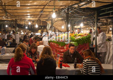 Horizontale Ansicht von Touristen Essen auf das Essen Ständen in Place Djemaa el Fna (Djemaa el Fnaa) in Marrakesch in der Nacht. Stockfoto