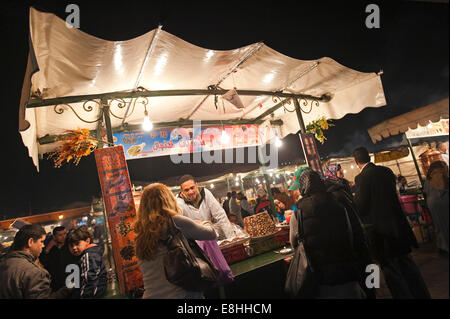 Horizontale Porträt eines weiblichen Touristen kaufen traditionellen Pfefferminztee zu einem in der Platz Jemaa el Fna (Djemaa El Fnaa) in Marrakesch Abschaltdruck Stockfoto